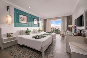 Une chambre d’hôtel avec un grand lit, un bureau et un balcon avec vue.