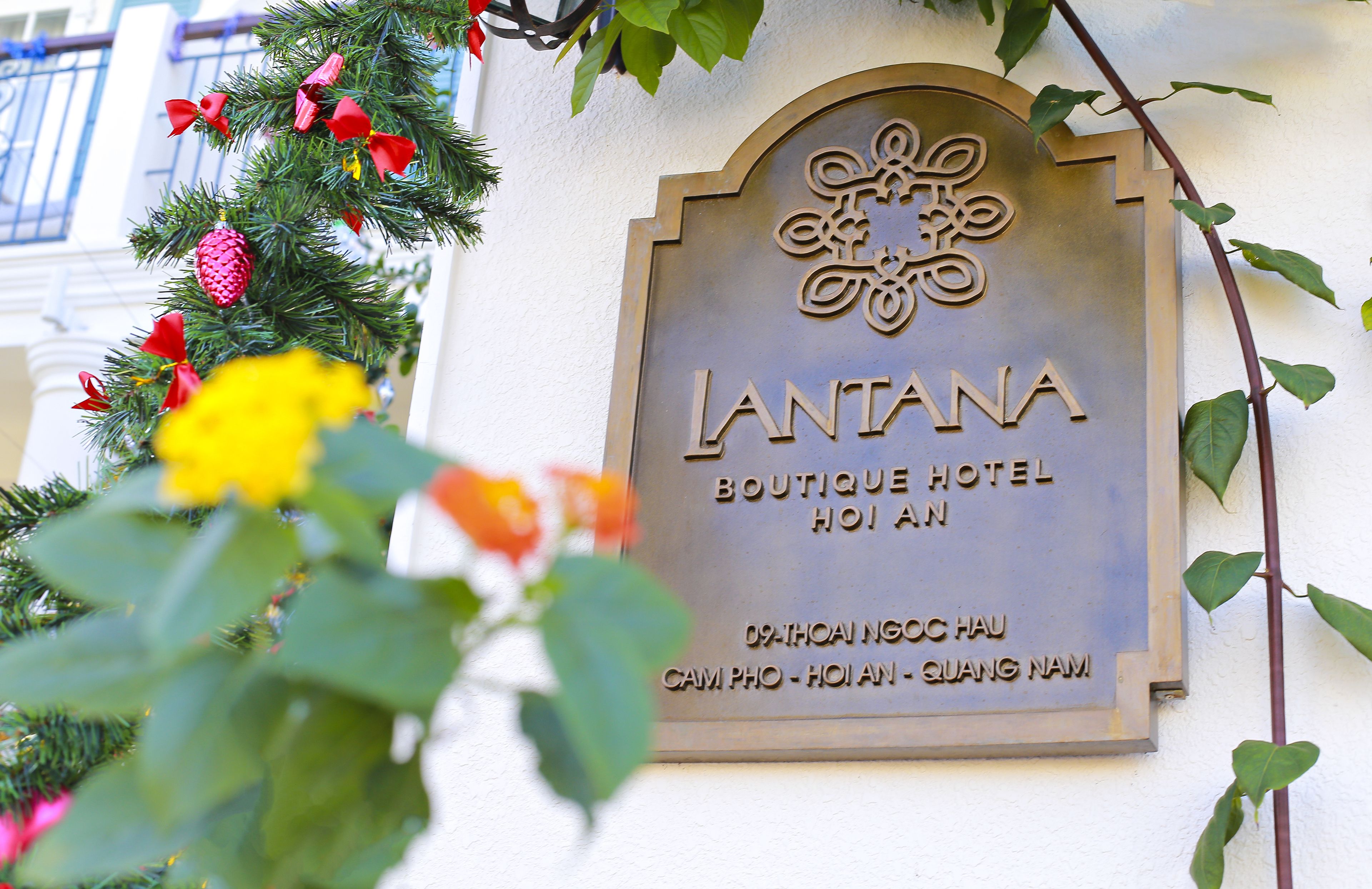 A sign for the LANTANA Boutique Hotel, including its name and location in Cam Pho, Hoian, Quang Nam.