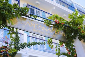 Señal del HOTEL & SPA LANTANA, con balcón y plantas decorativas.
