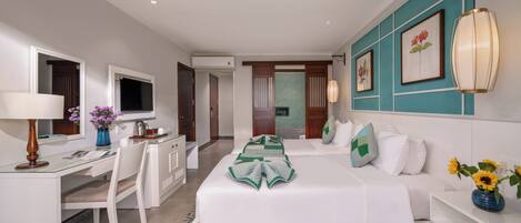 A hotel room with a bed, desk, chair, and a television.