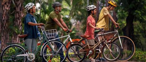 Cuatro personas en bicicleta en un entorno natural exuberante y verde.