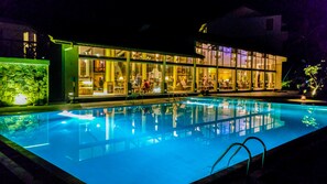 Una piscina al aire libre, sombrillas, tumbonas