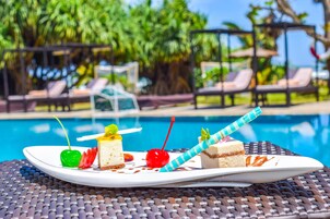 A dessert plate with various treats by a poolside.