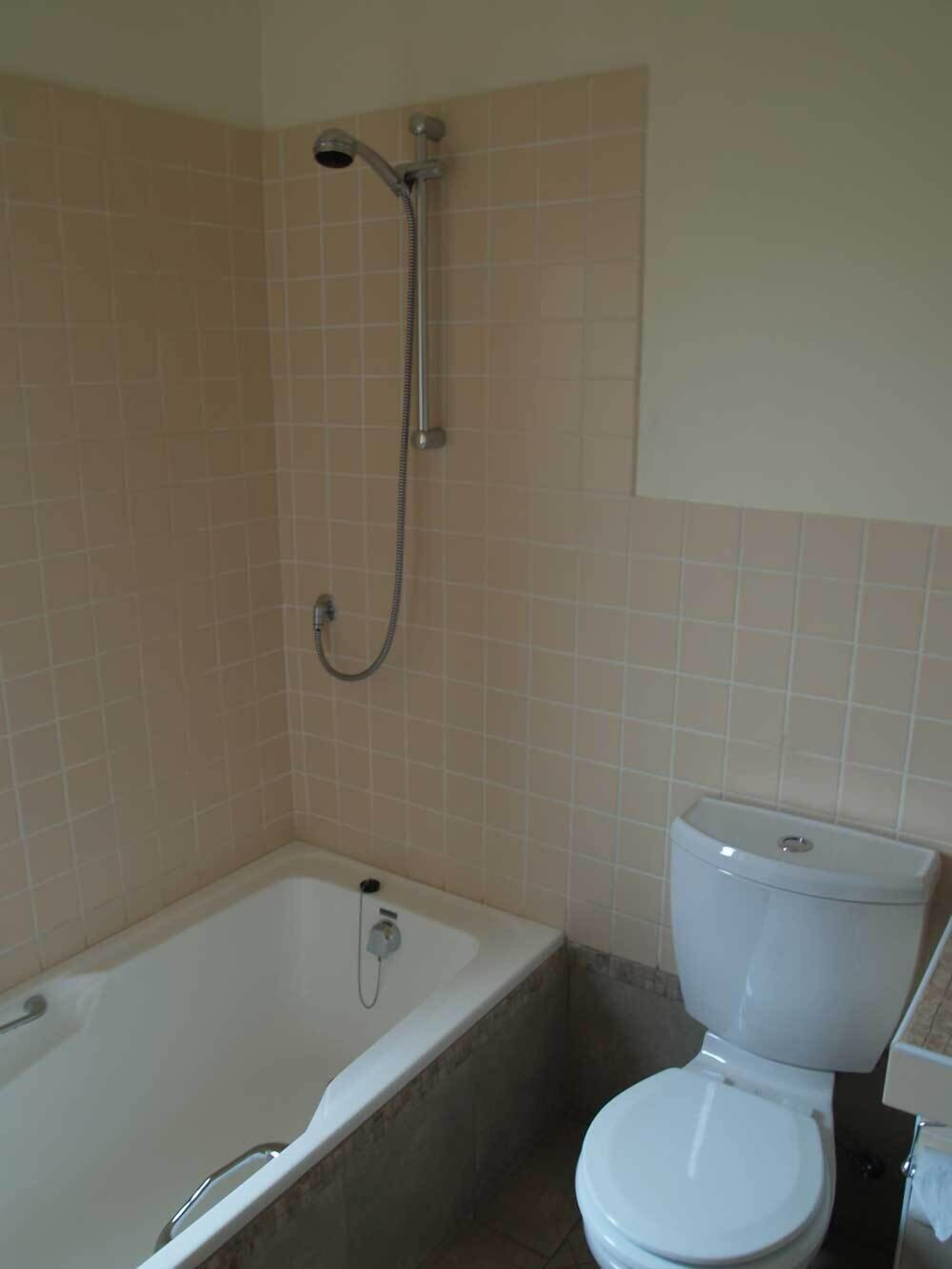 Une salle de bain avec une baignoire, des toilettes et une douche.