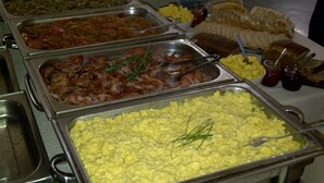 Un bufé con diversas opciones de comida, incluyendo huevos, tocino y ensaladas.