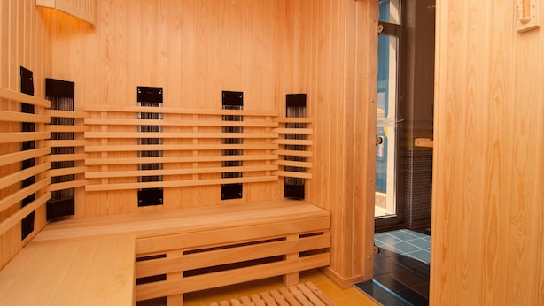 Een houten sauna met banken en ventilatiepanelen.