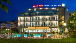 Een hotel met een zwembad, terras en een bordje waarop een 5-sterren beoordeling staat.