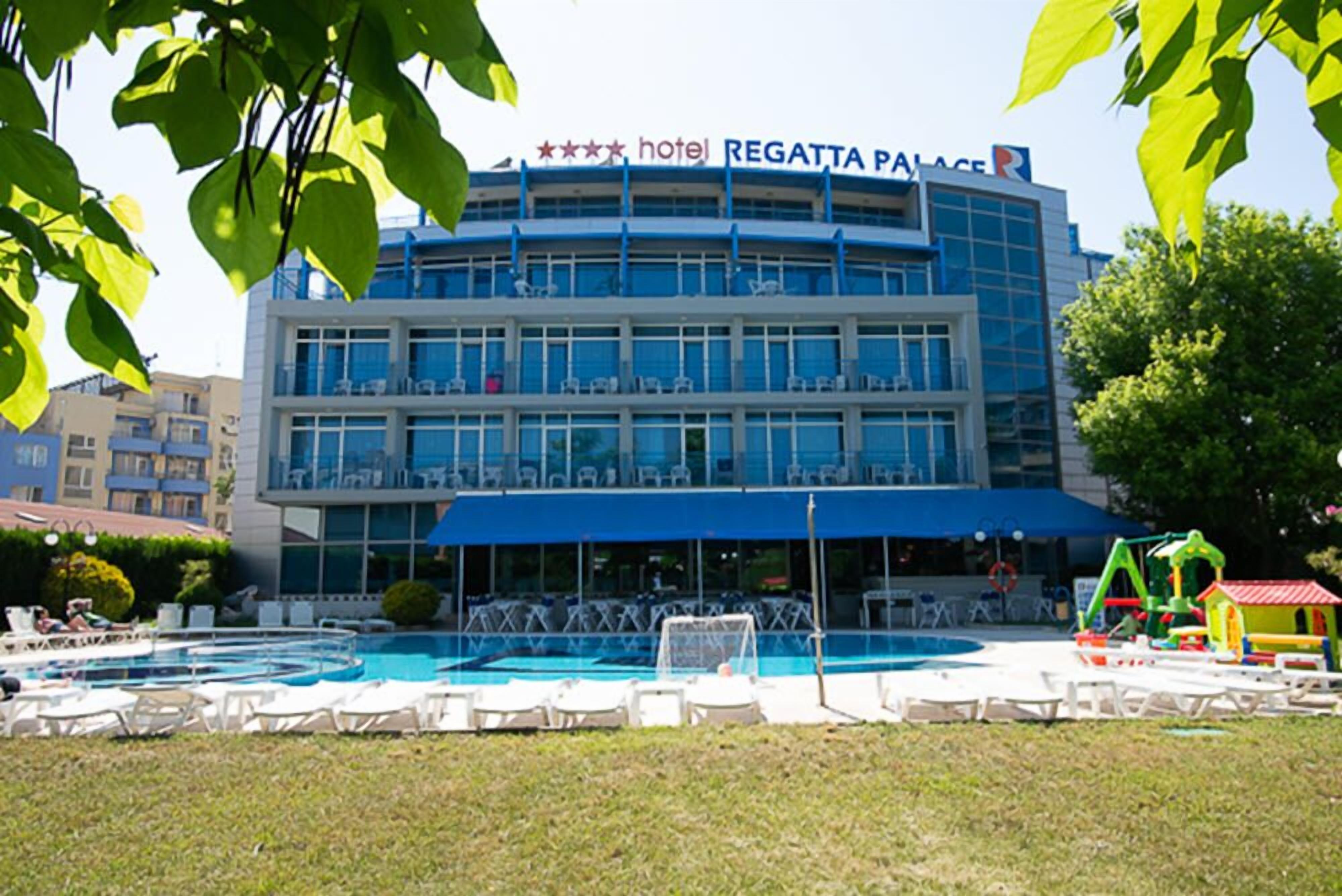 A hotel with a swimming pool, outdoor seating, and a children's play area.