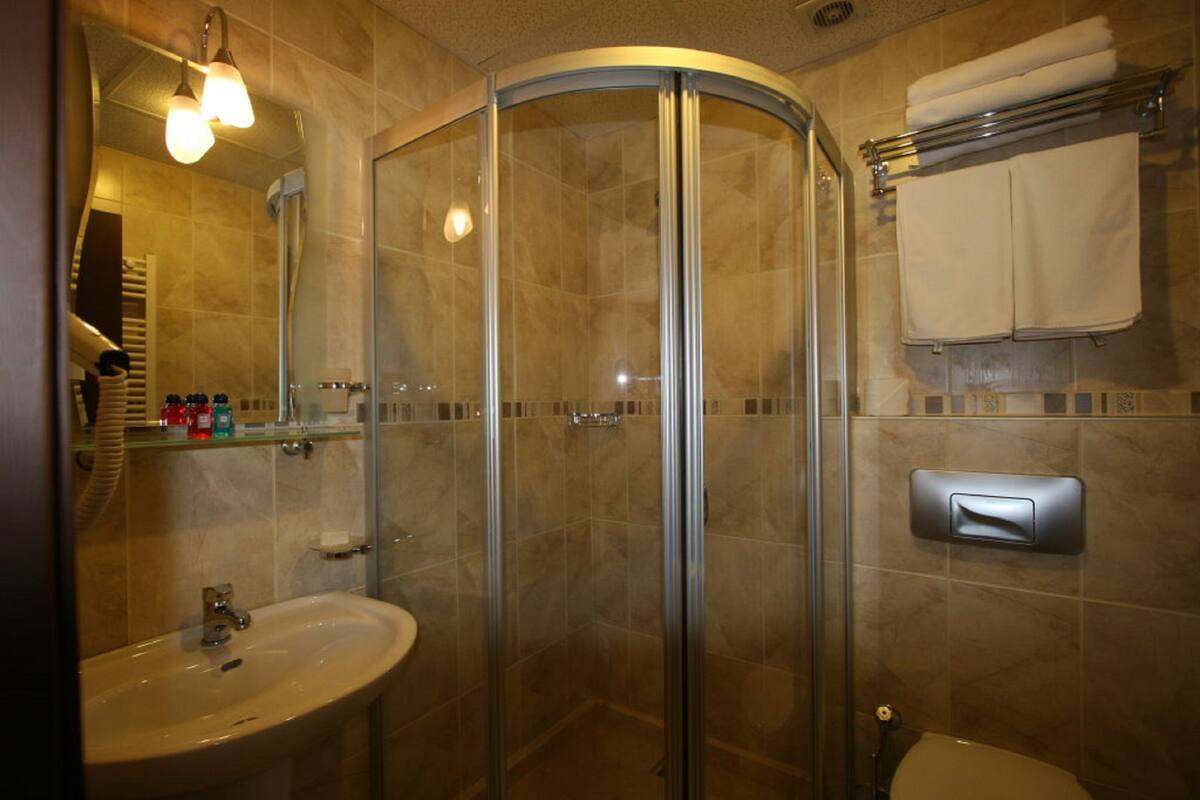 Une salle de bain avec une douche à parois de verre, un lavabo et des toilettes.