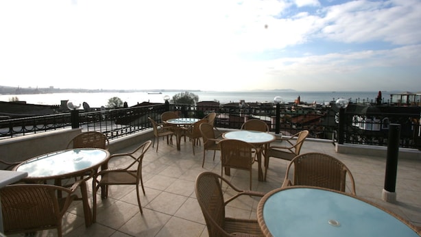 An outdoor terrace with wicker furniture and a view of the sea. - Grand Peninsula Hotel (Istanbul)