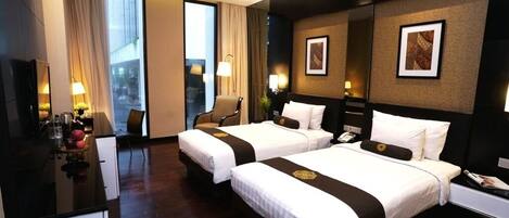 Een hotelkamer met twee bedden, een bureau en een stoel.