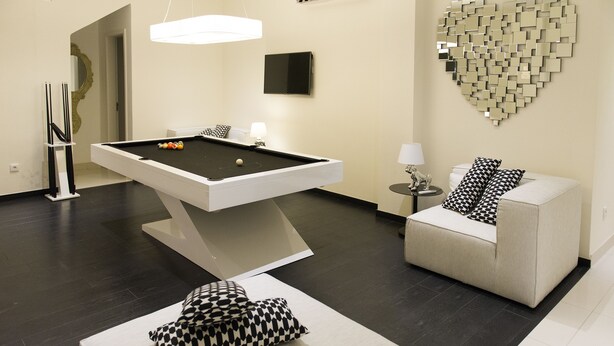 A modern room with a pool table, a sofa, and a decorative heart-shaped wall piece. - Nacala Plaza Business Design Hotel (Nacala)