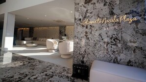 A modern interior with a marble wall, a sofa, and a coffee table. - Nacala Plaza Business Design Hotel (Nacala)