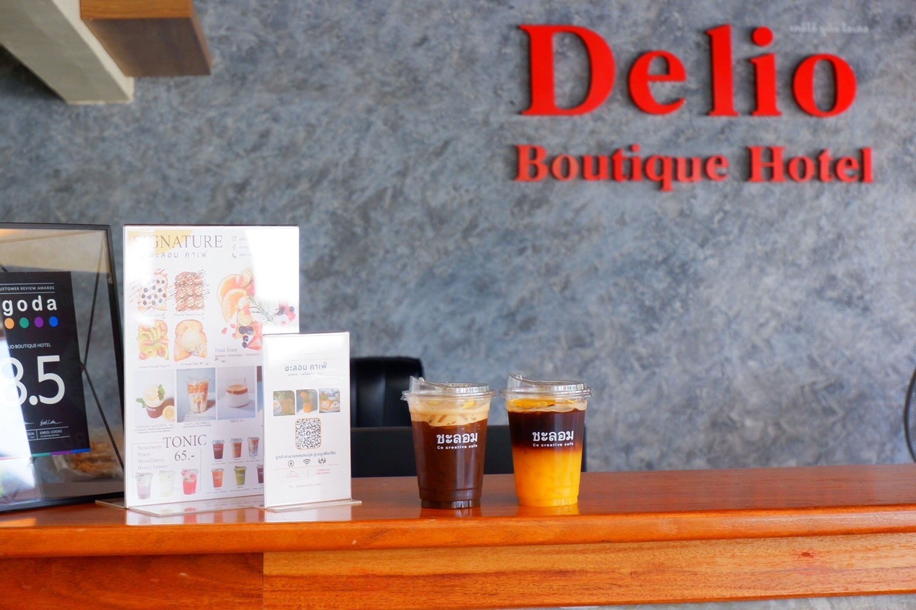 Mostrador de recepción en el Delio Boutique Hotel, con un menú y dos bebidas heladas.