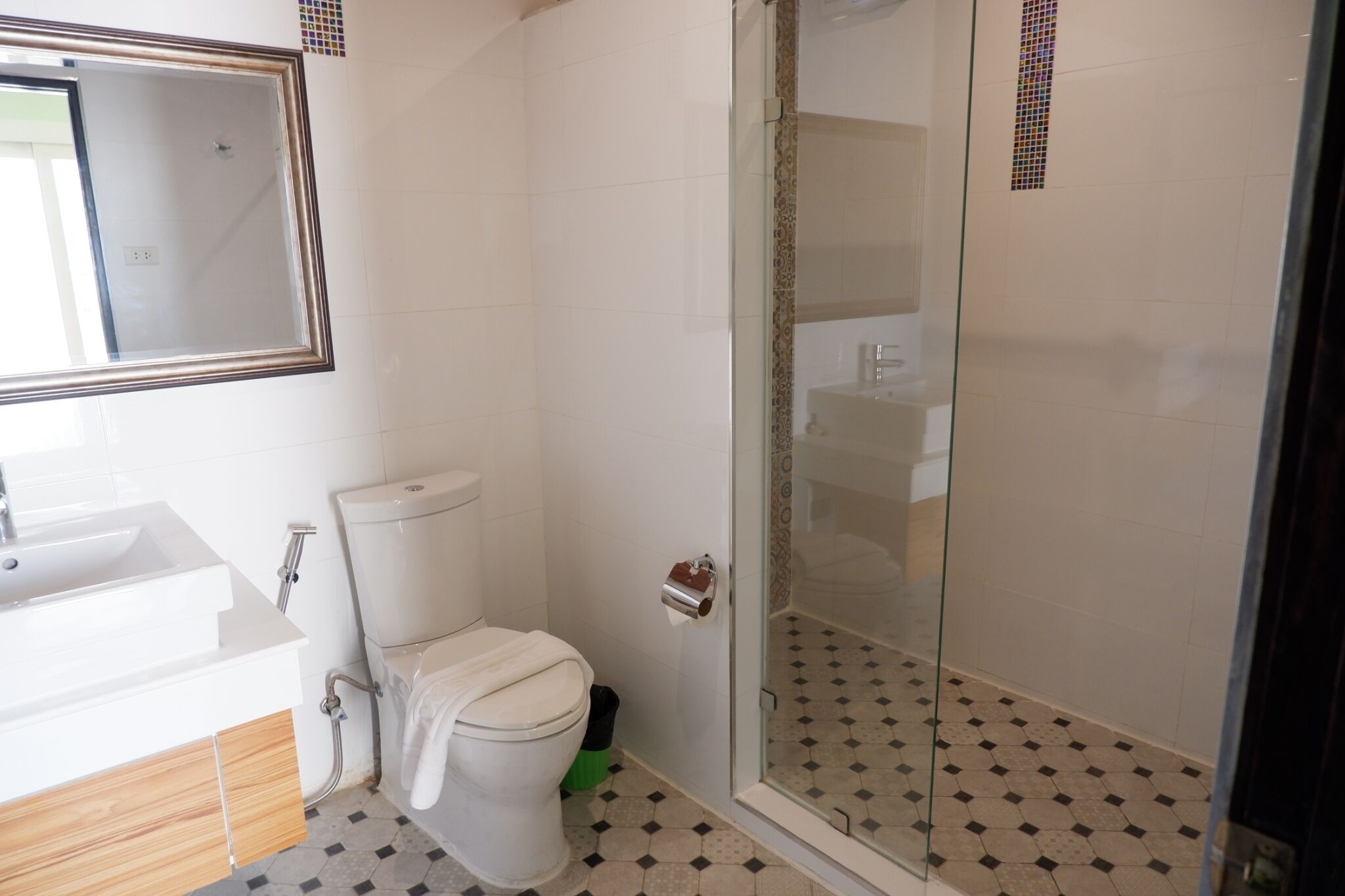 A bathroom with a toilet, sink, and shower area.