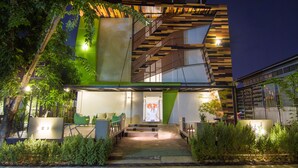 Un bâtiment moderne doté d’un escalier, d’un espace extérieur aménagé pour s’asseoir et de verdure.