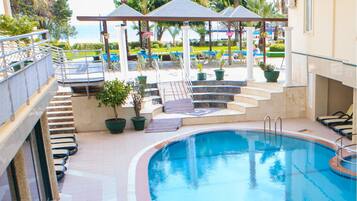 Una piscina al aire libre de temporada, sillones reclinables de piscina