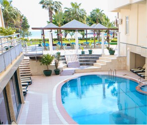 Una piscina al aire libre de temporada, sillones reclinables de piscina