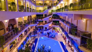 A multi-level hotel atrium with a central swimming pool, multiple balconies, and indoor plants. - L'ancora Beach Hotel (Kemer)