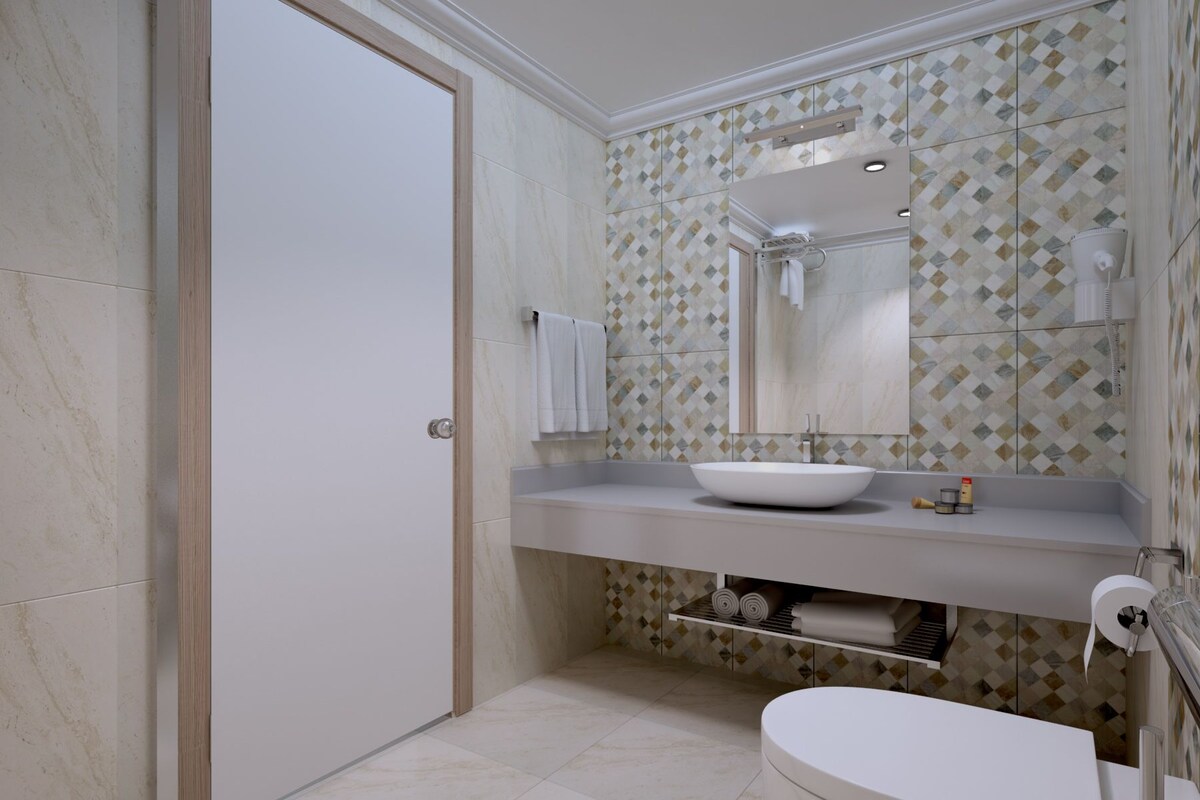 A bathroom with a white sink, a mirror, and a toilet.