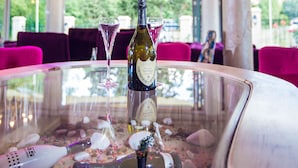A dining table with a bottle of wine, a martini glass, and a bottle of champagne. - Avenue Deluxe (Sunny Beach)