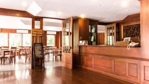 Un restaurant spacieux, doté de meubles en bois et d’un plafond haut.