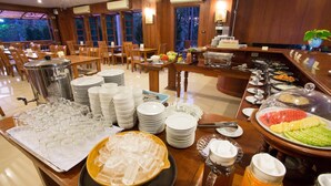 Un buffet proposant une variété de plats, d’assiettes et de verres, le tout disposé sur des tables.