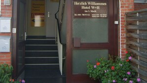 En hotellentréd med en skylt där det står ”HOTEL W+H”.