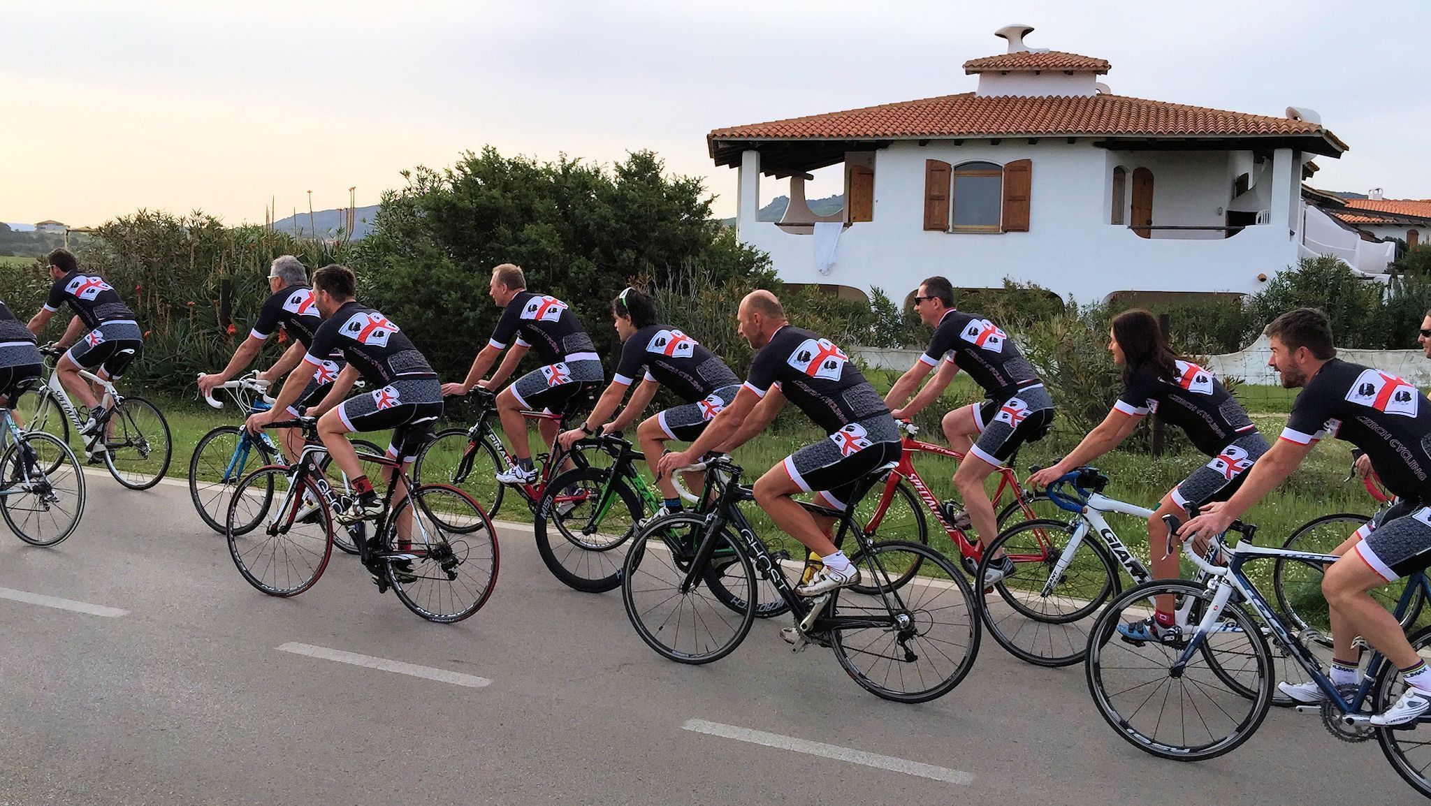 Un grupo de ciclistas con uniformes iguales pedaleando por una carretera.