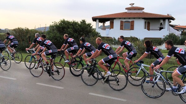 A group of cyclists in matching uniforms riding on a road. - Sa Fiorida Case Vacanze (Valledoria)