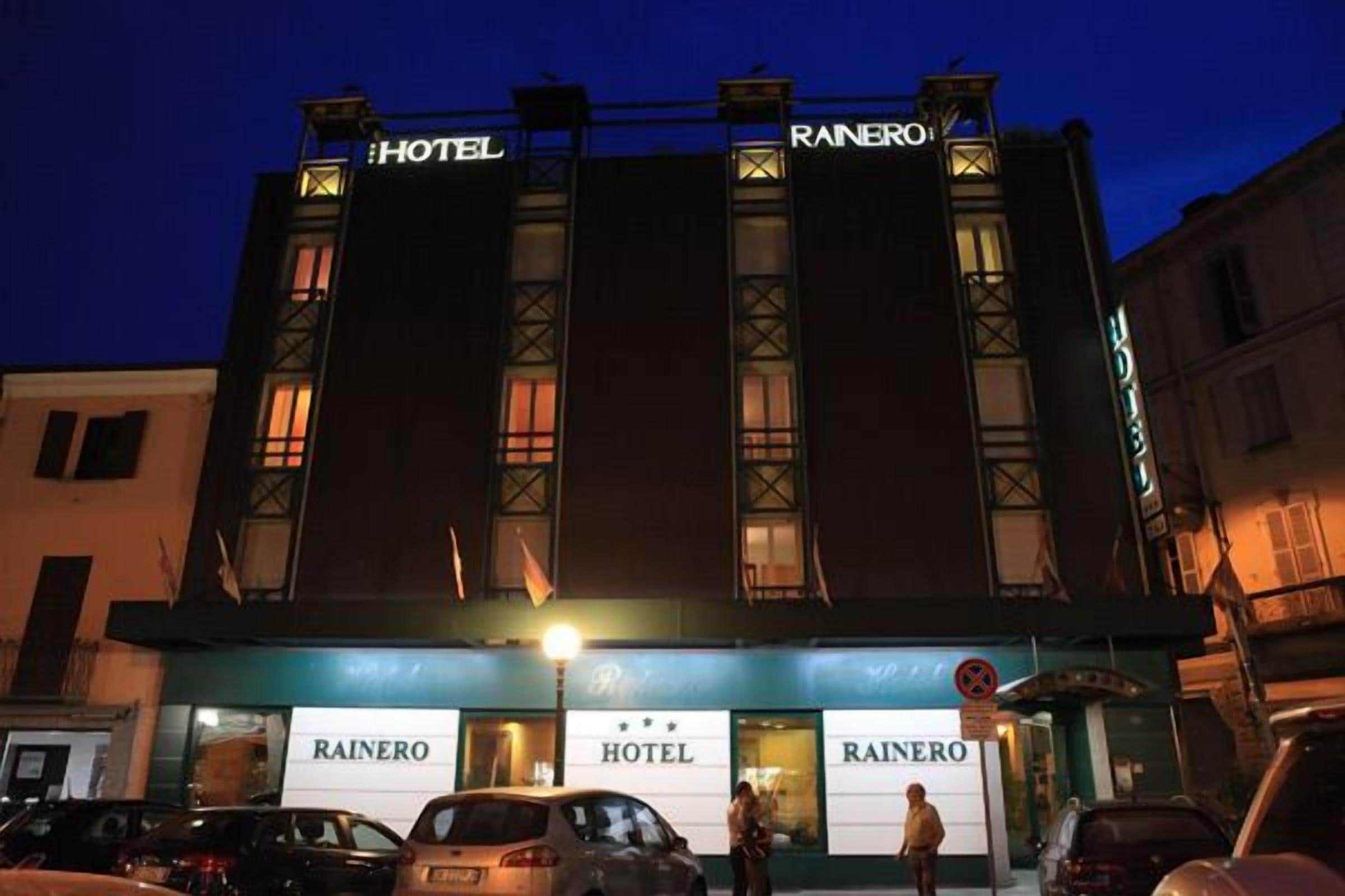 Un hotel llamado 'Rainero' con una fachada moderna, múltiples ventanales y un cartel que indica que no hay estacionamiento.