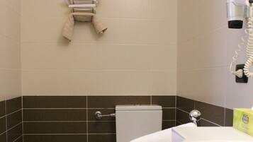 A bathroom with a bidet, toilet, and sink.
