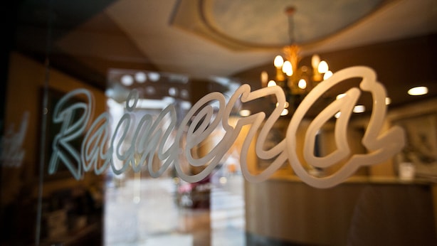 Un letrero de vidrio con la palabra "Raimona" escrita en caligrafía.