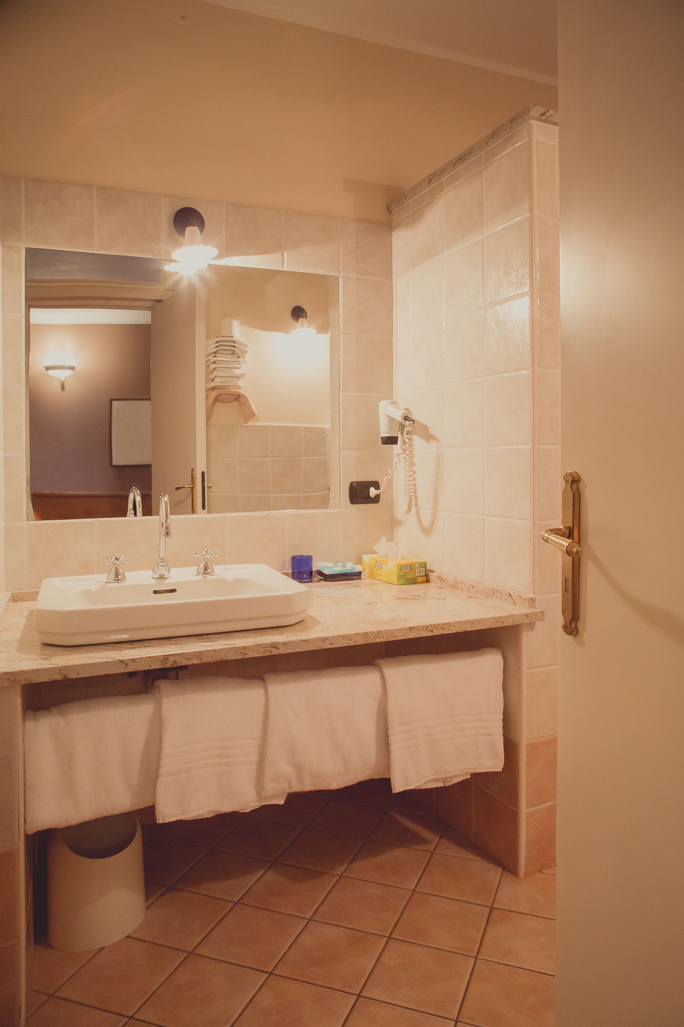 A bathroom with a sink, mirror, and towel rack.