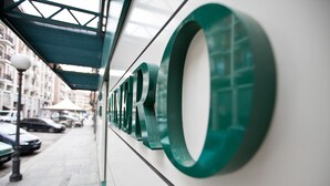 Fachada de un edificio moderno con letras verdes grandes que dicen 'HOTEL'.
