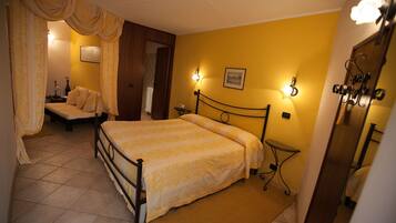 A bedroom with a bed, bedside tables, a nightstand, and a mirror.