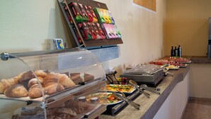 A buffet with various food items, including pastries and pizzas, and a selection of beverages. - Casa Alkea (Brenzone sul Garda)