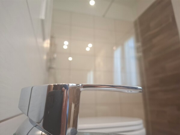 Un baño de diseño moderno, con grifo cromado y inodoro blanco.