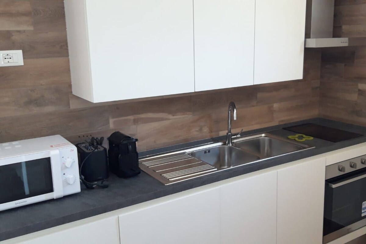 A compact kitchen with a microwave, sink, and oven.