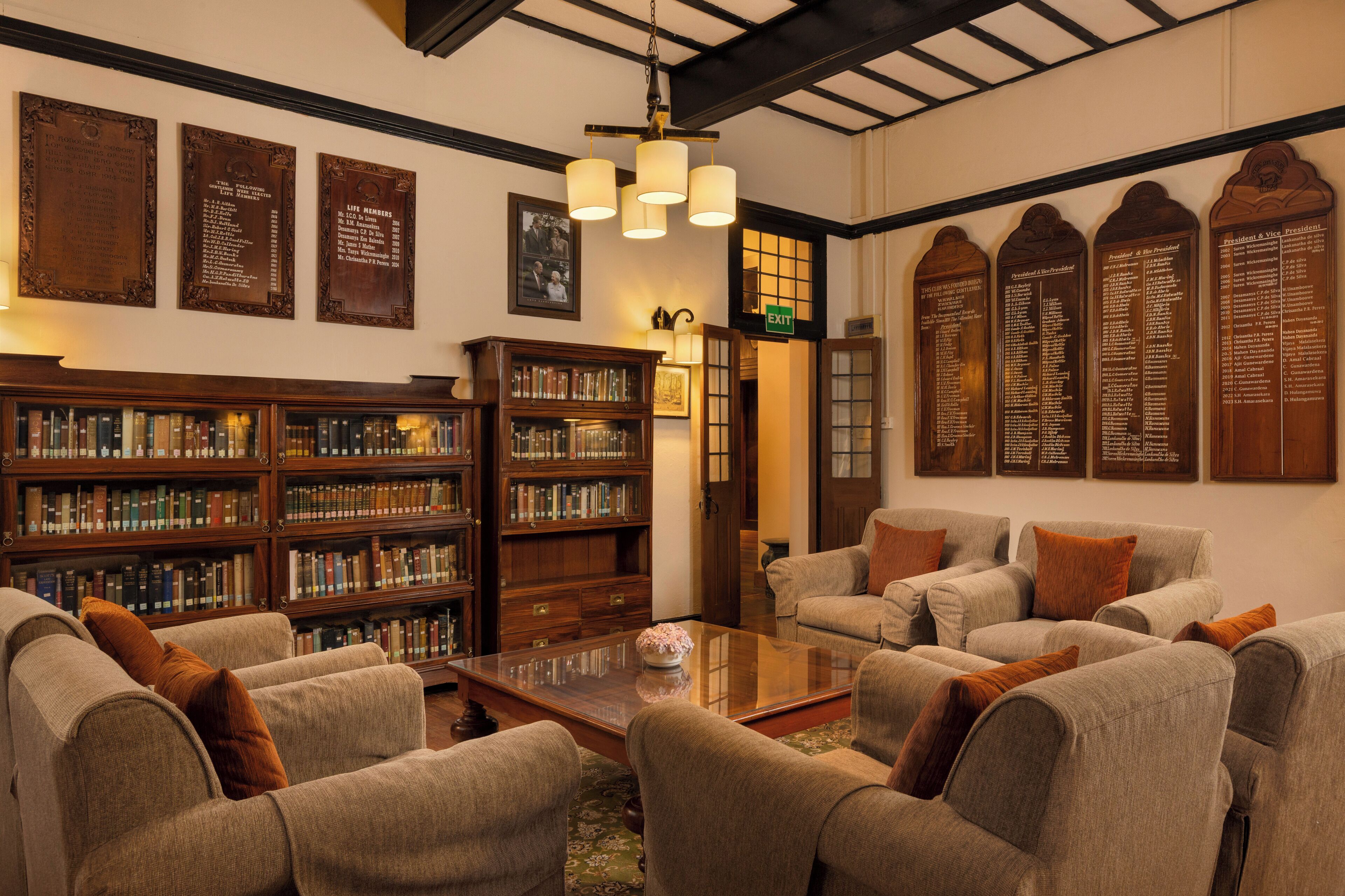 A library with bookshelves, a coffee table, and seating area.