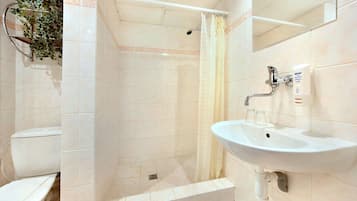 Un baño con ducha, inodoro y lavamanos.