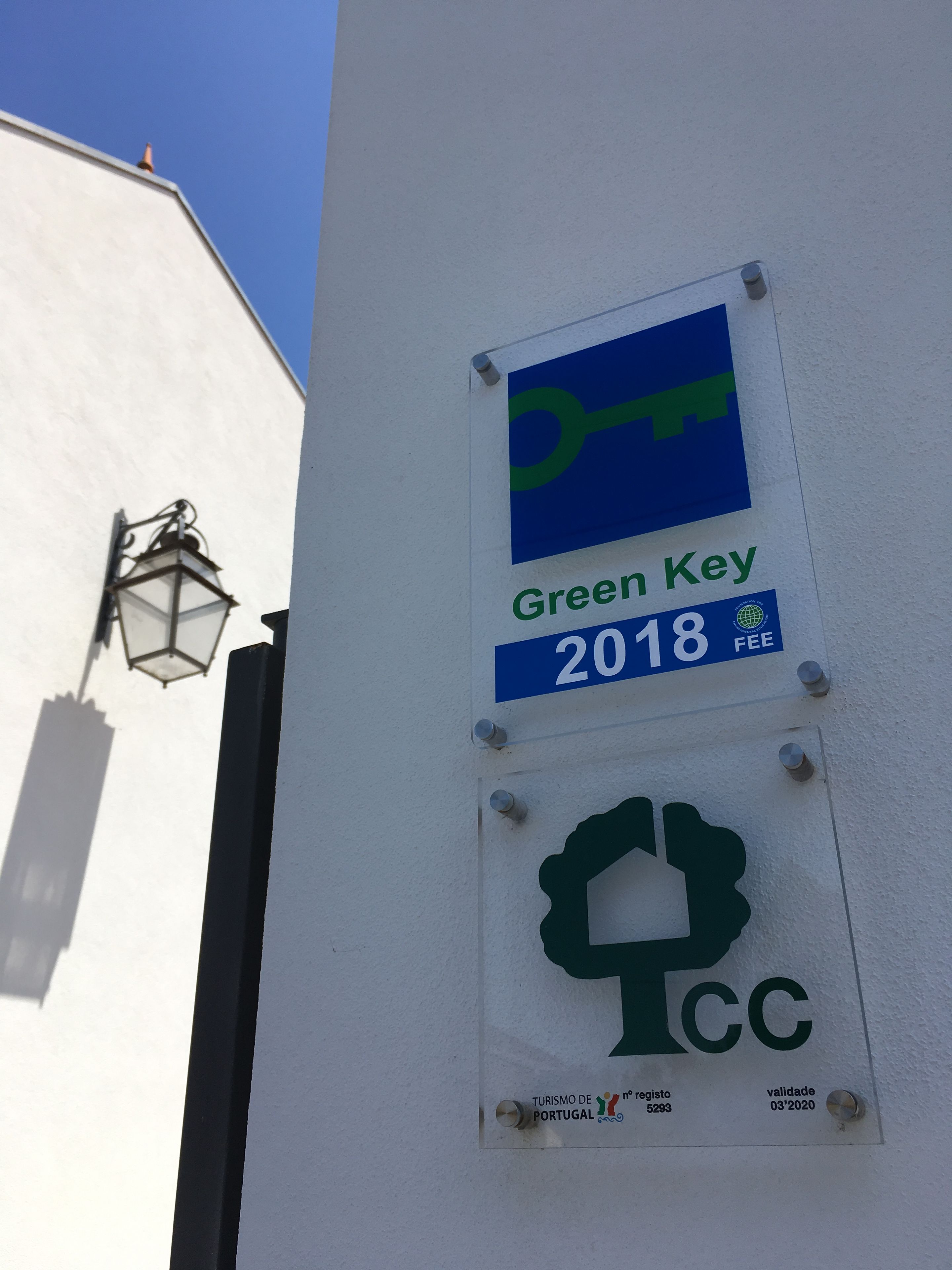 Un muro con un cartello 'Green Key 2018 FEE' e il logo 'TURISMO DE PORTUGAL'.