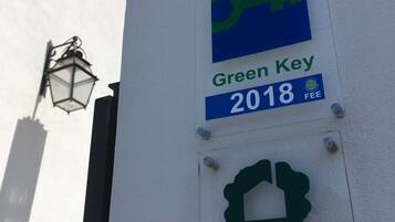 Un muro con un cartello 'Green Key 2018 FEE' e il logo 'TURISMO DE PORTUGAL'.