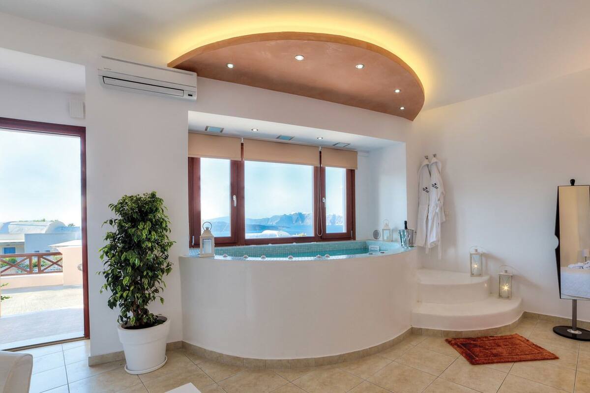 A modern bathroom with a curved bathtub, a potted plant, a large window with a view, and a mirror.