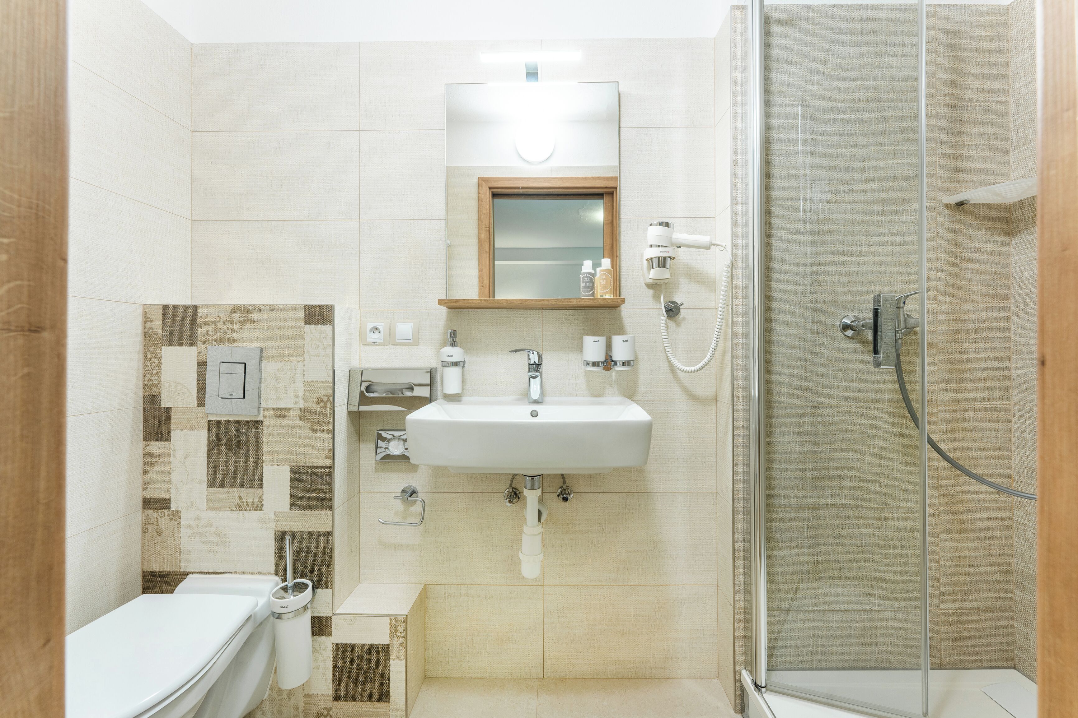 A modern bathroom with a shower, toilet, and sink.