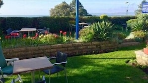 A patio area with a table and chairs, a blue pole, and a view of the sea. - Hotel Riviera (Bournemouth)