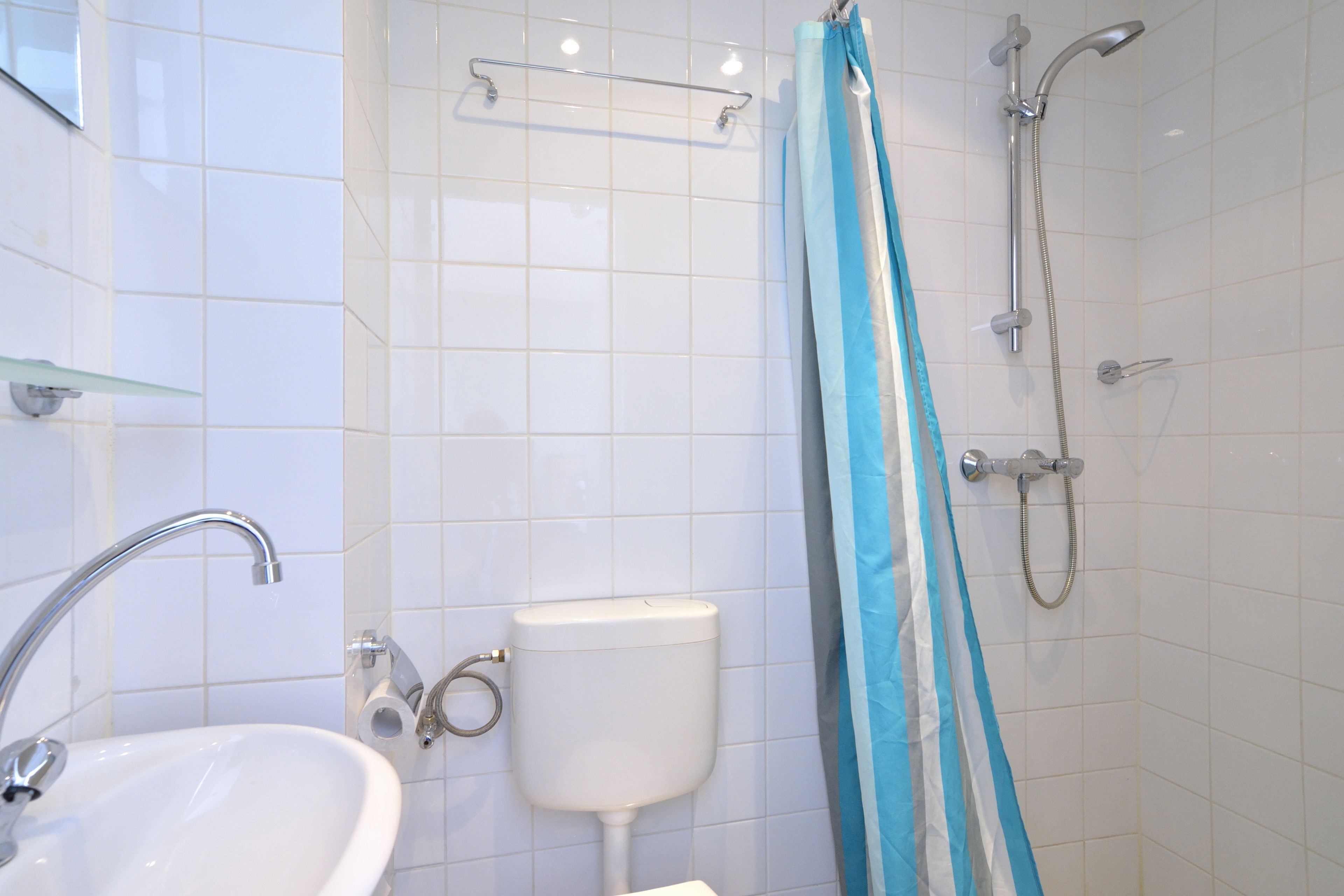 A bathroom with a sink, toilet, and shower.
