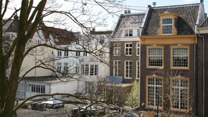 A row of traditional European-style buildings with distinct architectural features, including gabled roofs and large windows.