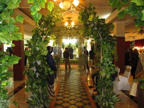 A corridor with a patterned floor, a chandelier, and a crowd of people. - Pondok Serrata Convention, Boutique & Tourist Hotel (Semarang)