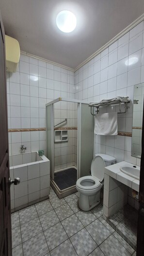 A bathroom with a toilet, sink, shower, and a mirror. - Pondok Serrata Convention, Boutique & Tourist Hotel (Semarang)